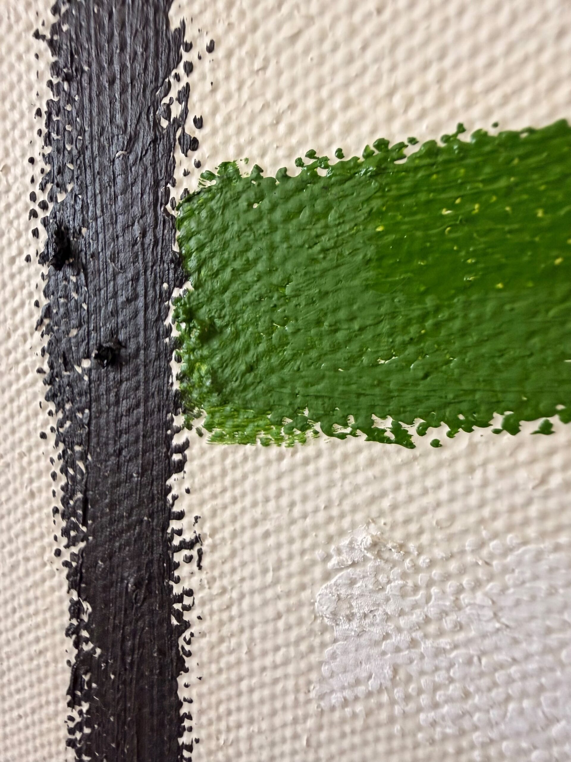 Detalle de una pintura con trazos verdes y negros sobre una superficie blanca